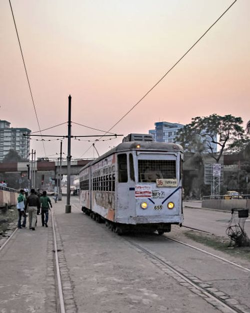Colorful tram moving through busy, streets of Kolkata on background of beautiful Sunset. Kolkata, West Bengal, India-January 28th,2012: Colorful tram moving through busy, streets of Kolkata on background of beautiful Sunset. kolkata-tram stock pictures, royalty-free photos & images