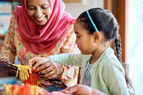 girl and grandmother making wau bulan at home - making wau stock pictures, royalty-free photos & images