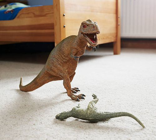 two toy dinosaurs fighting in childs room - toy-dinosaur-fight stock pictures, royalty-free photos & images
