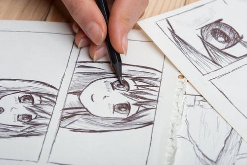 Artist drawing an anime comic book in a studio.
