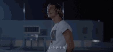 a man in a white shirt with a necklace around his neck says l-i-v-i-n