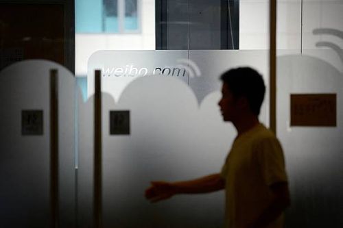 Man walks into an office of Sina Weibo, widely known as China's version of Twitter, in Beijing on April 16. Sina Weibo is set to go public in the US...