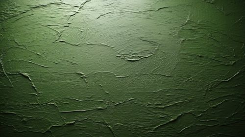 Dark olive green textured wall with light reflecting top and shadows bottom Abstract
