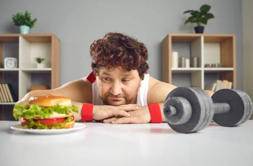 Funny sad chubby man choosing between gym dumbbell and delicious unhealthy burger Funny upset depressed fat athlete choosing between gym dumbbell and delicious cheeseburger. Concept of sport, choice, willpower, healthy weight loss fitness exercise vs yummy unhealthy fast food diet dieting funny stock pictures, royalty-free photos & images