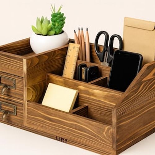 May include: A wooden desk organizer with multiple compartments and drawers. It contains a small potted succulent, pencils, a ruler, scissors, a stapler, a smartphone, and a notepad. The organizer is stained a dark brown color.