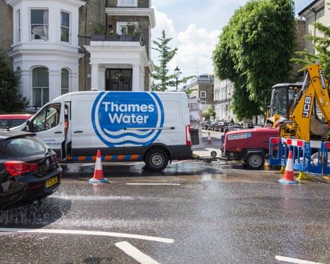 A Thames Water van and excavator with traffic cones surround a burst water main repair site