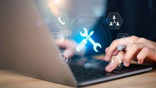 IT support and digital tools concept. Person using laptop with glowing wrench and screwdriver , representing system maintenance, tech service, customer support, and online troubleshooting in business