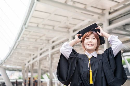 Woman bachelor`s degree wearing graduate dress with holding hat in city. Bachelor s degree stock images, royalty-free photos and pictures