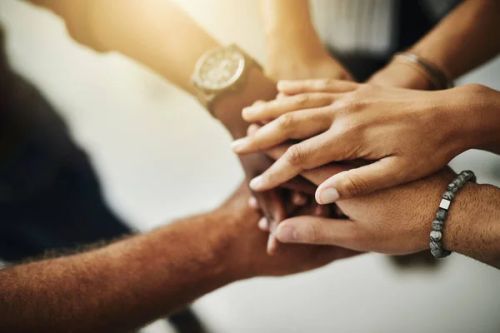 Everyone benefits if we work together. Closeup shot of a group of unrecognizable businesspeople joining their hands together in a huddle. — Stock Photo, Image