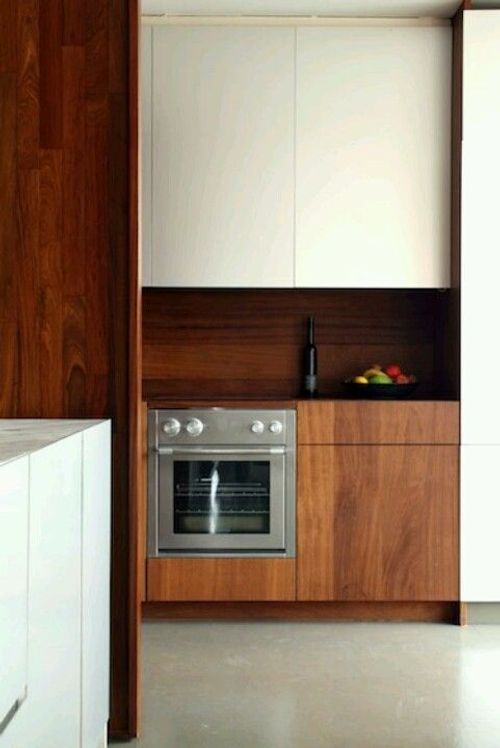 a modern kitchen with white cabinets and stainless steel stove top oven, built into the wall