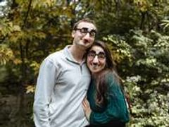 Couple poses for the camera wearing funny glasses.