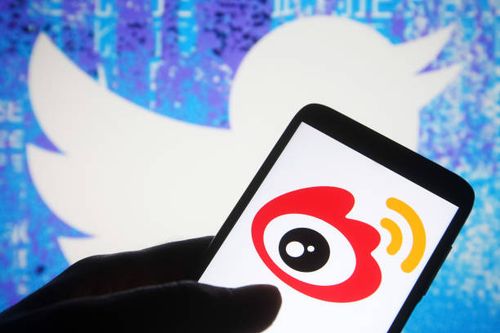 In this photo illustration a Weibo logo of a Chinese social media platform is seen on a smartphone with a Twitter website in the background.