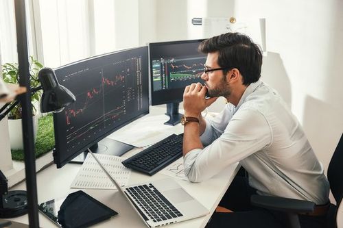 A person looking at a stock chart on a computer screen.
