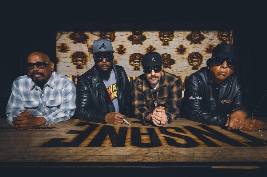 Eric Bobo, B-Real, DJ Lord and Sen Dog of Cypress Hill pose for a portrait behind a sign that says Insane.