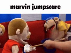 a group of stuffed animals are sitting on a red couch and a person is holding a toothbrush .