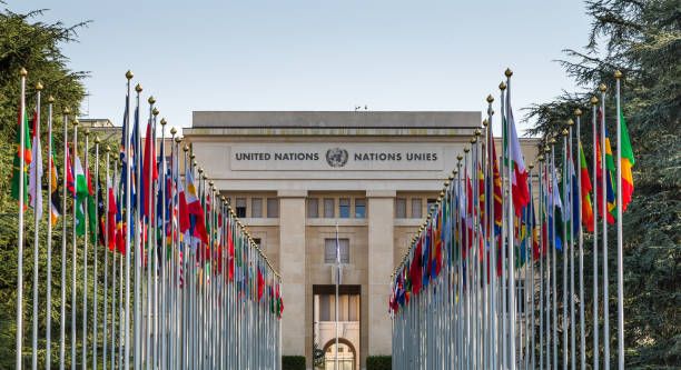 Headquarters of United Nations (UN) in Geneva, Switzerland Geneva, Switzerland - 6 August, 2019: color image depicting the exterior architecture of the United Nations (UN) building in the city of Geneva, Switzerland. The front of the building is lined with many flags and flagpoles, representing all the member nations of the UN. Room for copy space. nations stock pictures, royalty-free photos & images