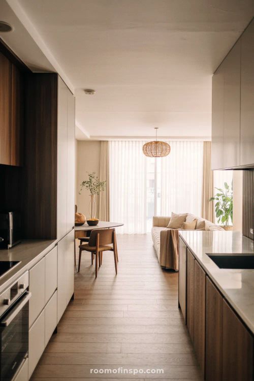 A bright, unique kitchen featuring a large central island, light wood tones, and an eclectic mix of modern and traditional elements.