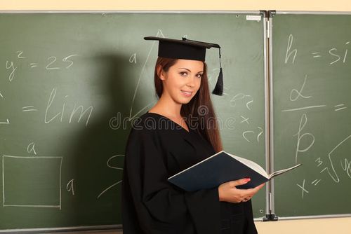 Educational theme: graduating student in academic gown in a classroom. Bachelors degree stock images, royalty-free photos and pictures