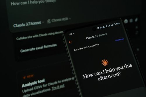 Dhaka, Bangladesh - 16 March 2025: The app of the claude 3.7 sonnet is displayed on a smartphone screen, and the website claude is visible on a computer screen in the background.