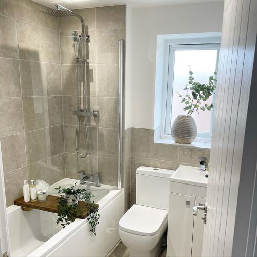 A small bathroom with eucalyptus leaves