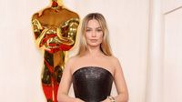 Margot Robbie Forgoes Barbie Colors in a Black Versace Gown at the 2024 Oscars