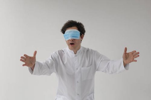 curly doctor with facial mask on his eyes - confused doctor stock pictures, royalty-free photos & images