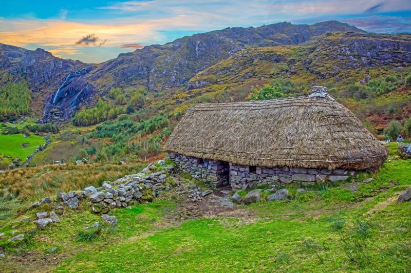 Stone cottage with green hills behind