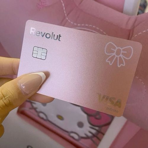 a person holding up a pink hello kitty credit card