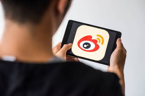 Man holds an Apple iPad Mini as he uses Weibo app on October 4, 2017 in Hong Kong, Hong Kong.