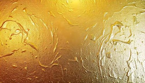 Metallic paint splatter texture with reflective gold and silver tones photo