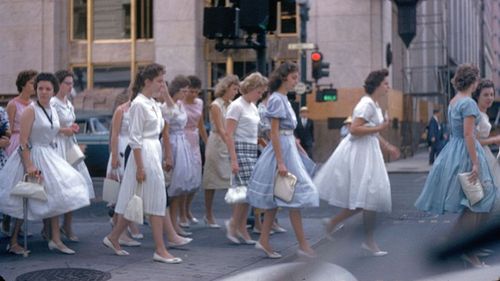 Group of young white women in 1950s-style dresses.