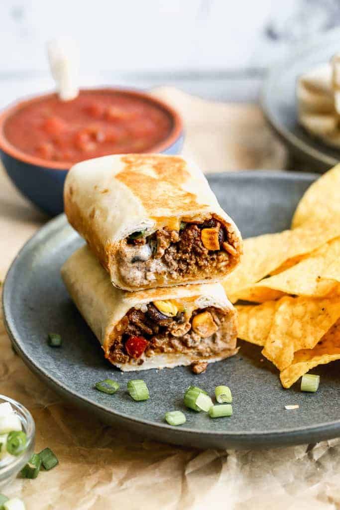 Crispy southwest wrap stacked on a plate, with chips.