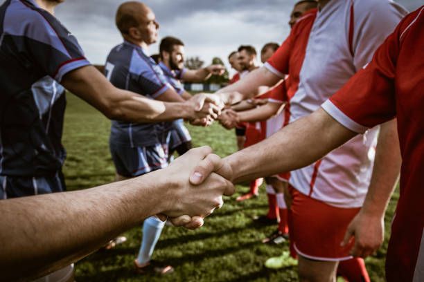 Close up of good sportsmanship on the field. Close up of players of two sports teams shaking hands before the game on the field. sportsmanship stock pictures, royalty-free photos & images