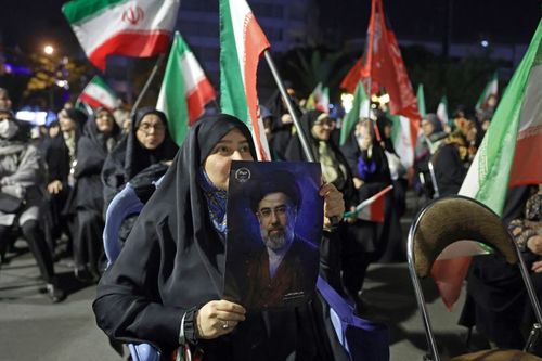 A woman holds a portrait of Iran's Supreme Leader Mojataba Khamenei during a protest against the US and Israel in Tehran