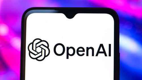 OpenAI logo seen on a smartphone on a pink and purple background.