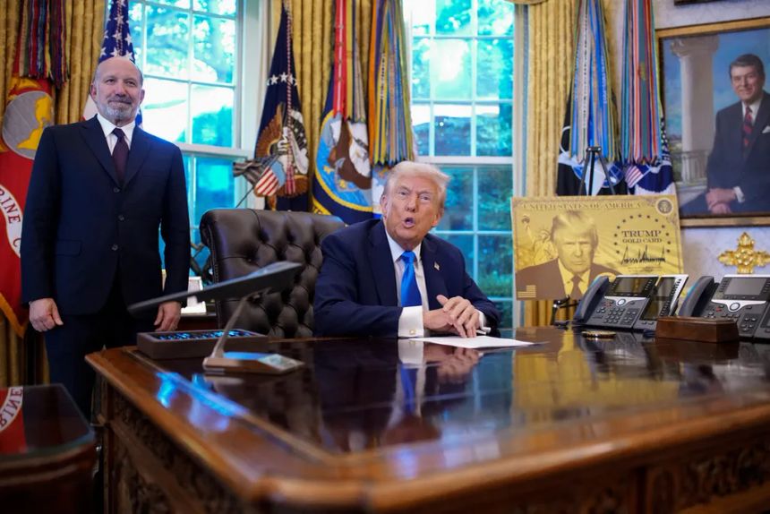 Presiden Amerika Serikat Donald Trump, didampingi Menteri Perdagangan Howard Lutnick (kiri), menyampaikan pidato di samping poster 'Kartu Emas Trump' sebelum menandatangani perintah eksekutif di Ruang Oval, Gedung Putih, Washington DC, Jumat (19/9/2025).