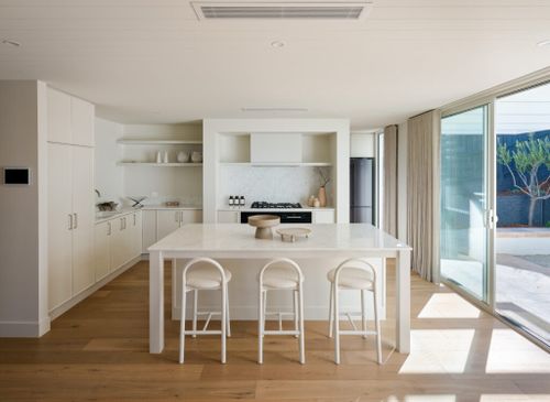 Contemporary L-shaped kitchen layout featuring Caesarstone Mineral ™ Surface island, seamless cabinetry and generous workspace for social cooking.