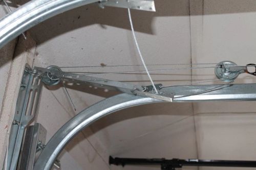 Garage door cable repair close-up view.