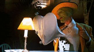 a man with a green mask on his face is sitting at a table next to a lamp