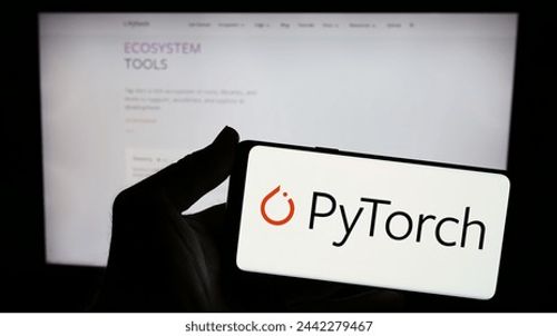 Stuttgart, Germany - 03-12-2024: Person holding smartphone with logo of machine learning library PyTorch in front of website. Focus on phone display. Unmodified photo. Editorial Stock Photo