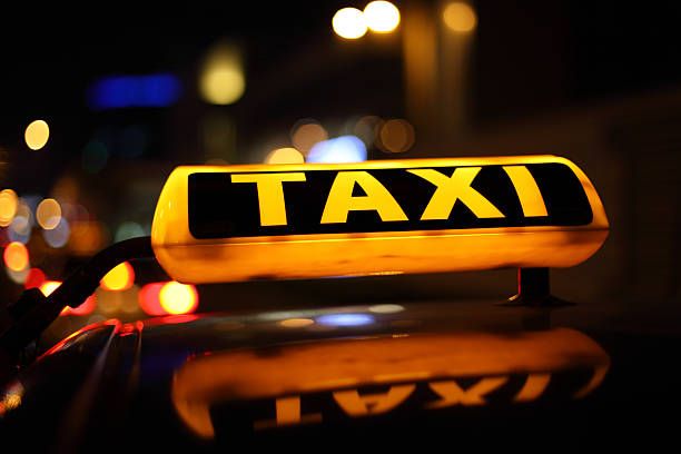 Yellow taxi sign Yellow taxi sign illuminated at night yellow taxi stock pictures, royalty-free photos & images
