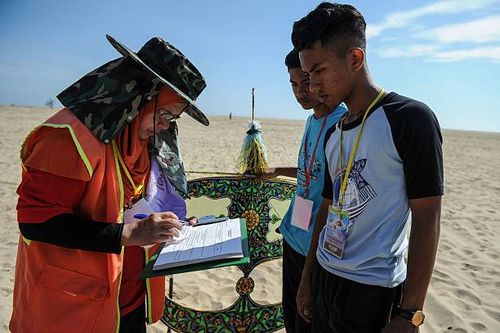 Referee inspects a traditional Malaysian kite known as "Wau Bulan" before flying during the annual kite festival at Pantai Genting beach in Tumpat on...