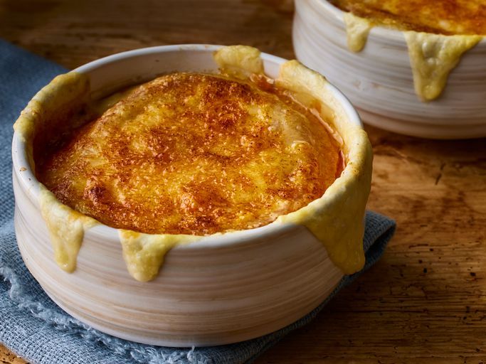 close up on a bowl of French onion soup gratinee with melted cheese on top