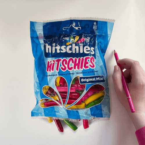 r/drawing - a hand holding a pencil next to a bag of candy
