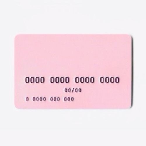 a pink credit card sitting on top of a white table