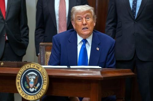 arafed image of a man in a suit and tie sitting at a desk