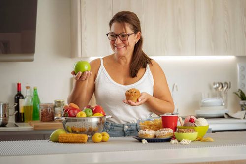 woman chooses healthy food rather than junk food - fat people eating donuts stock pictures, royalty-free photos & images