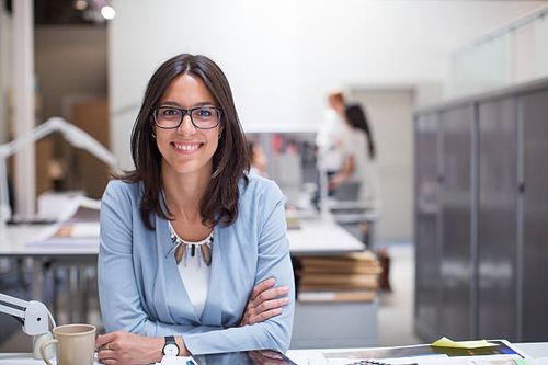 business woman sitting at her desk in corporate office. - professional woman at desk stock pictures, royalty-free photos & images