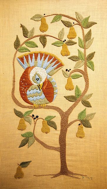 an embroidered bird sitting on top of a tree with pears in the foreground