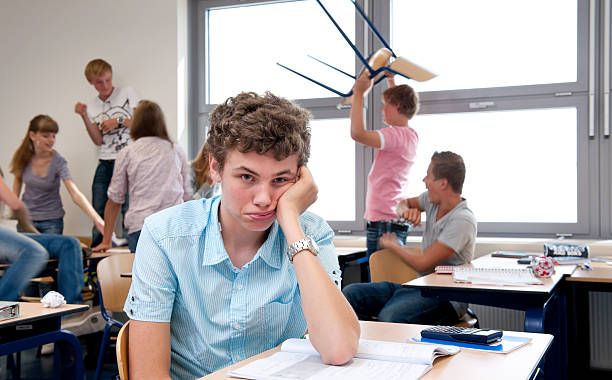 triste high school boy in caótica con montaje tipo aula - desorden en clase fotografías e imágenes de stock